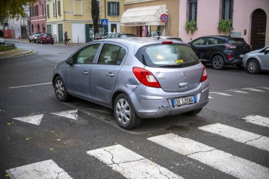 Lombardy, İtalya - 20 Kasım 2024 hafif hasarlı gümüş opel Corsa 1.3 Cdti kentsel bir çevrede yaya geçidinde park halinde.