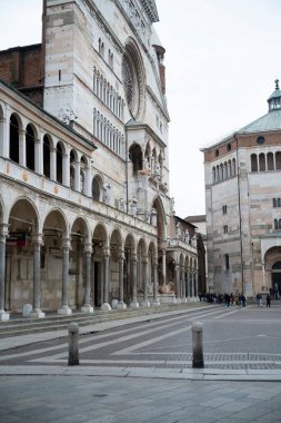 Cremona, İtalya - 20 Kasım 2024 Piazza del comune, bulutlu bir günde duomo ve baptistery eşliğinde Cremona 'da yürüyen turistler