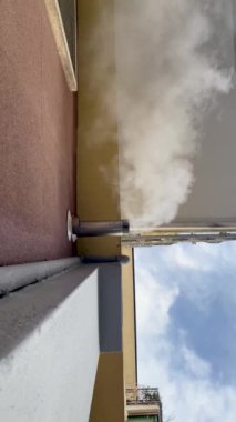 Cremona, İtalya - 9 Aralık 2024 sonbahar sezonu boyunca bacadan çıkan beyaz duman bulutlu mavi gökyüzüne vuruyor