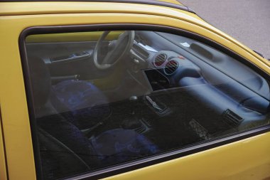 Cremona, Italy - January 15th 2025 Interior view of a yellow Renault Twingo, focusing on the steering wheel, dashboard, and patterned seats clipart