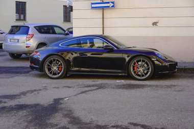 Cremona, Italy - January 15th 2025 Dark blue Porsche 911 991.2 Carrera 4S with petrol engine parked near a silver Toyota RAV4 clipart