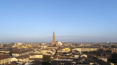 Aerial view of Cremona city center featuring the iconic Torrazzo bell tower of the Cathedral, surrounded by historic buildings and a clear blue sky during a crisp winter day in Lombardy, Italy clipart