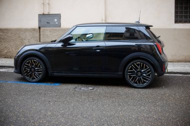 Cremona, İtalya - 15 Ocak 2025 Black Mini Cooper SE Electric Caddenin kenarına park etti