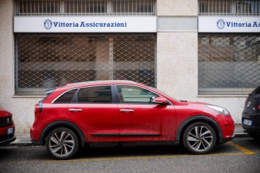 Cremona, İtalya - 15 Ocak 2025 Red Kia Niro Vittoria Assicurazioni 'nin önüne park etti.