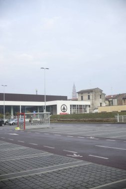 Cremona, İtalya - 15 Ocak 2024 Büyük otopark otobüs durağı, bisiklet parkı ve süpermarket, Cremona, İtalya 'da, Torrazzo arka planda
