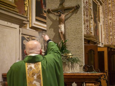 Cremona, İtalya - 9 Şubat 2025 Katolik rahip, İtalya 'nın Cremona kentindeki Santa Maria Assunta Katedrali' nde yapılan ayin sırasında haçı ateşledi.