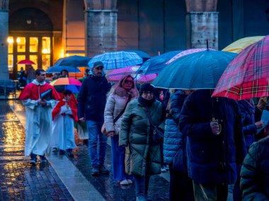 Cremona, İtalya - 9 Şubat 2025 Altar çocukları İtalya 'daki Cremona katedralinden ayrılan renkli şemsiyeler altında katolik geçit törenine liderlik ediyorlar.