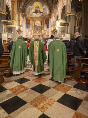 Cremona, Italy - February 9th 2025 Priests wearing green chasubles walking in procession inside the Cathedral of Santa Maria Assunta during a religious service in Cremona, Italy clipart