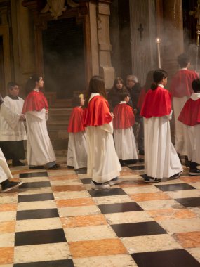 Cremona, İtalya - 9 Şubat 2025 Papaz yardımcılarından oluşan bir grup, İtalya 'nın Cremona kentindeki Santa Maria Assunta Katedrali' nde düzenlenen ayin sırasında yürüyüş yapıyor.