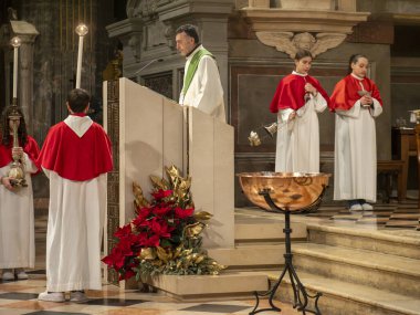Cremona, İtalya - 9 Şubat 2025 'te İtalya' nın Cremona kentindeki Santa Maria Assunta Katedrali 'nde rahip, rahip, rahip, papaz yardımcısı oğlanlar ve kırmızı pelerinli kızlar