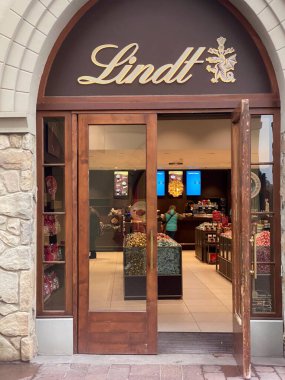 Lindt Çikolata Dükkanı 'nın açık kapısı, İtalya' daki Fidenza Village lüks mağazasında renkli çikolatalarla dolu rafları gösteriyor.