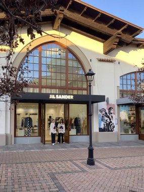 Fidenza Village 'daki Jil Sander mağazasının önünde duran müşteriler. Milan, İtalya yakınlarındaki lüks bir moda mağazası.