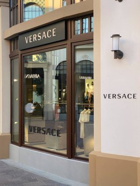 Büyük vitrinlerde, İtalya 'nın Milano kenti yakınlarındaki lüks bir outlet mağazası olan Fidenza Village' daki Versace mağazasında lüks giysiler ve aksesuarlar sergileniyor.