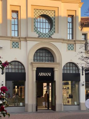 İtalya 'da lüks bir mağaza olan Fidenza Village' da alışveriş çantasıyla Armani mağazasından çıkan müşteri, üst düzey moda ve tasarımcı markalarının yer aldığı bir mağaza.