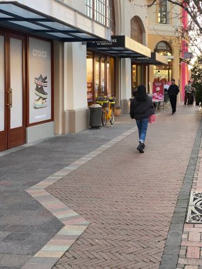 İtalya 'da lüks bir mağaza olan Fidenza Village' da lüks moda markaları ve mağazaları olan alışveriş merkezi gezen bir müşteri.