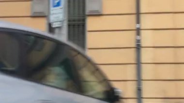 Bolonya, İtalya 7 Şubat 2025 İkametgâh binaları ve park halindeki arabalar Bologna, İtalya 'da bir cadde boyunca hareket halindeki araçlar şehir yaşamını gözler önüne seriyor.