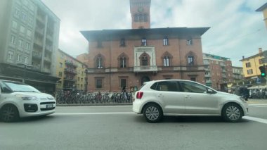 Bolonya, İtalya 7 Şubat 2025 Tarihsel Palazzo d 'Accursio Bolonya sokaklarını hareketlendirerek, hareket halindeki trafik ve mimari ihtişam vasıtasıyla İtalyan kentinin yaşamını ele geçirdi.