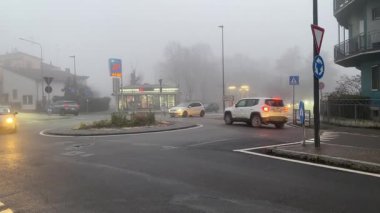 Cremona, İtalya 9 Şubat 2025 'te İtalya' nın Cremona şehrinde sisli bir sabahta, küçük bir binanın yanından geçen bir kavşakta çok sayıda araba sürüyordu.