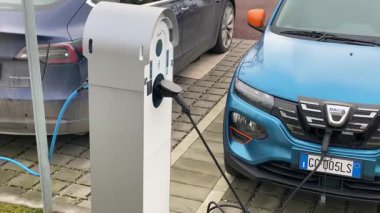 Cremona, İtalya 9 Şubat 2025 elektrikli araçlar Tesla Model 3 ve Dacia Spring Cremona 'da sürdürülebilir hareketlilik ve temiz enerji altyapısını temsil eden şehir istasyonunda şarj oluyorlar.