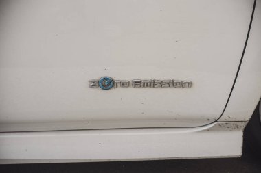 Cremona, İtalya 9 Şubat 2025 Beyaz Nissan Yaprağı üzerindeki sıfır emisyon logosunu kapat, Çevre dostu ulaşım ve daha yeşil bir geleceğe olan bağlılığını vurgula
