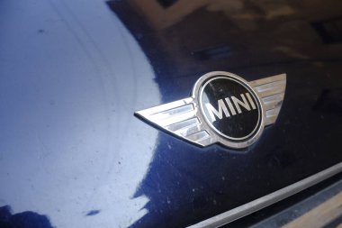 Cremona, İtalya 9 Şubat 2025 Parlak Krom MINI logosu, İngiliz otomotiv markasının sembolik amblemini gösteren temiz, parlak bir mavi araba kaputunu yansıtıyor.