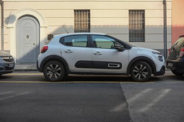 Cremona, İtalya 9 Şubat 2025. Cremona caddesinde park halindeki beyaz bir Citroen C3 'ün yan görüntüsü, İtalya' da şehir parkını gösteriyor.