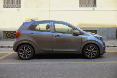Cremona, İtalya 9 Şubat 2025 'te İtalya' nın büyüleyici kenti Cremona 'daki bir cadde boyunca park etmiş gri renkli bir Kia Picanto' nun modern tasarımını gözler önüne serdi.
