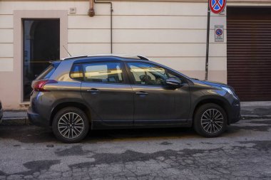 Cremona, İtalya 9 Şubat 2025 Koyu gri Peugeot 2008 bir İtalyan şehrinin hareketli kentsel manzarasına uyum sağlayarak park levhasının yanına park etti.