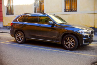 Cremona, İtalya 9 Şubat 2025 Koyu mavi BMW X5 SUV bir şehir caddesine park edilmiş, parlak tasarımı ve lüks özellikleri sarı bir bina zemininde sergilenmektedir.