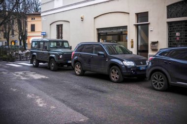 Cremona, İtalya 9 Şubat 2025 Bir şehir caddesinde park edilmiş arabalar, bir Land Rover Defender, bir Suzuki Grand Vitara ve bir Mazda CX 3