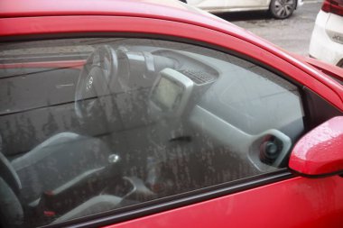 Cremona, Italy February 9th 2025 Interior view of a red Toyota Aygo showing steering wheel, dashboard and gear stick through a misted side window clipart