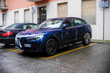 Cremona, İtalya 9 Şubat 2025 Mavi Alfa Romeo Stelvio 2.2 180 HP AT8 Q4 siyah bir Mercedes Benz E sınıfı Cabriolet 'in yanına park edilmiştir.