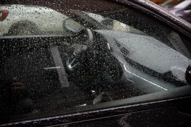 Cremona, İtalya 9 Şubat 2025 Araba penceresine yapışan yağmur damlaları iç mekanı göremez, soyut bir su damlası deseni oluşturur