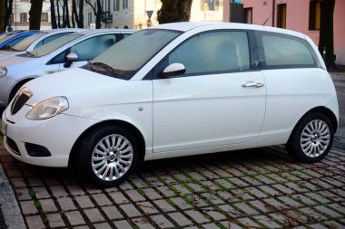 Cremona, İtalya 9 Şubat 2025 Beyaz Lancia Ypsilon 1.3 Multijet diğer araçlarla çevrili bir şehir ortamında parketmiş ve canlı bir şehir atmosferi yaratmıştır.