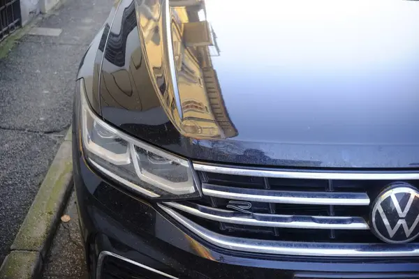 Cremona, İtalya 9 Şubat 2025 Siyah bir Volkswagen Touareg R 'in ön tarafı parlak kaputuna bir bina yansıtıyor.