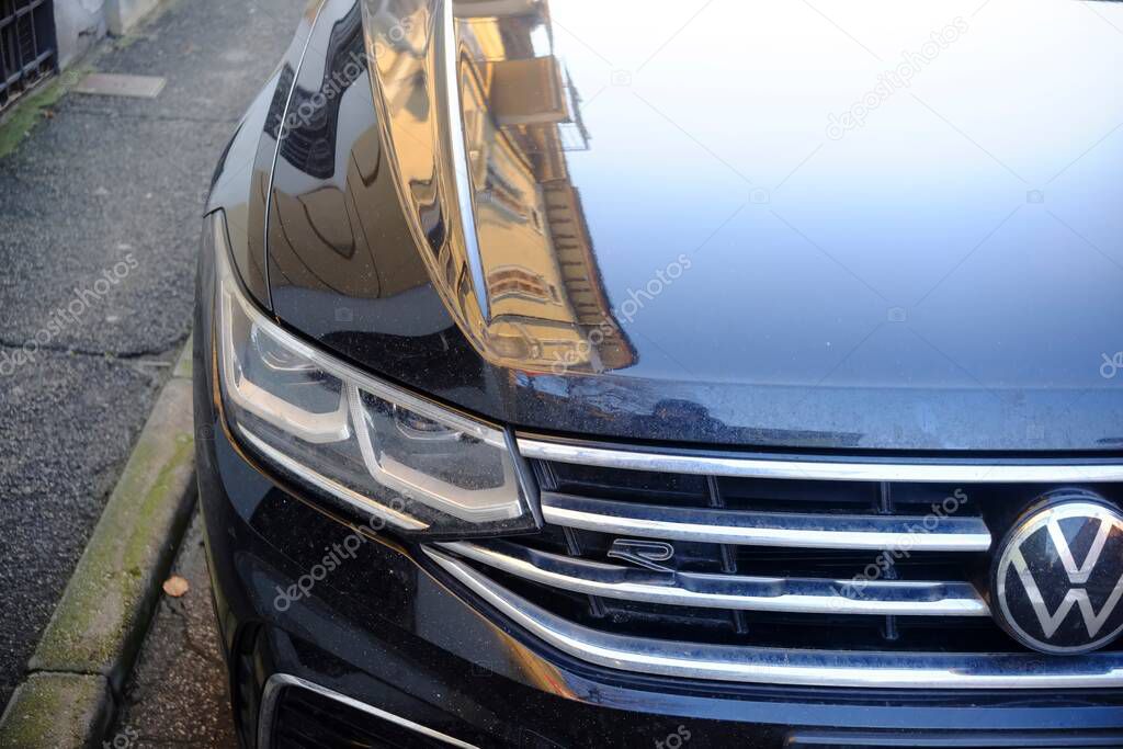 Cremona, Italy February 9th 2025 Detail of the front of a black Volkswagen Touareg R reflecting a building on its polished hood