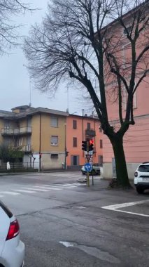 Cremona, İtalya 9 Şubat 2025 'te İtalya' nın Cremona kentinde soğuk bir kış sabahı sokak lambalarıyla aydınlatılan ıssız bir kavşağı kaplayarak gizemli ve anımsatıcı bir atmosfer yarattı.