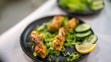 Lezzetli arzulu kebap, geleneksel Hint yemeği, taze salata ve limonla hazırlanmak, canlı bir restoran ortamındaki aşçılık deneyimine biraz tat ve tazelik katmak.