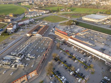 Castelvetro Piacentino, İtalya 21 Mart 2025 Iper Rossetto otoparkının hava aracı görüntüsü gün batımında parkedilmiş arabaları gösteriyor.