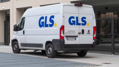 Bolonya, İtalya 7 Şubat 2025 Beyaz Fiat Ducato minibüsü GLS marka, modern bir binanın yanına park edilmiş, paketleri teslim etmeye hazır.