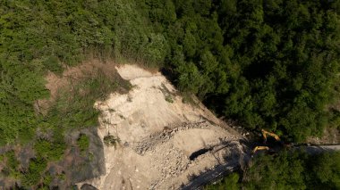 Mignano, İtalya - 22 Nisan 2025 SP21 Vernasca üzerindeki heyelana acil müdahale kazıcıların hızla dağ enkazı kaldırmasıyla, Piacenza, İtalya