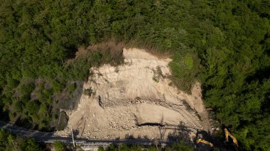 Mignano, İtalya - 22 Nisan 2025 SP21 Vernasca üzerindeki heyelana acil müdahale kazıcıların hızla dağ enkazı kaldırmasıyla, Piacenza, İtalya