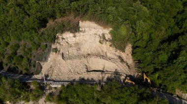 Mignano, İtalya - 22 Nisan 2025 SP21 Vernasca üzerindeki heyelana acil müdahale kazıcıların hızla dağ enkazı kaldırmasıyla, Piacenza, İtalya