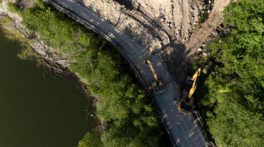 Mignano, İtalya - 22 Nisan 2025 Havadan çekilen ve Mignano Barajı 'nda engellenmiş SP21 Vernasca fotoğrafı, yol kenarında park halindeki kazıcılarla birlikte toprak kayması yaşıyor
