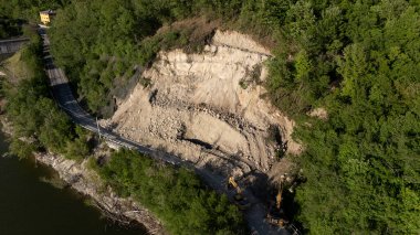 Mignano, PC, İtalya - 22 Nisan 2025 SP21 Vernasca 'nın yol kenarında park halindeki kazıcılarla birlikte toprak kayması sonucu engellenmiş havadan çekilmiş fotoğrafı