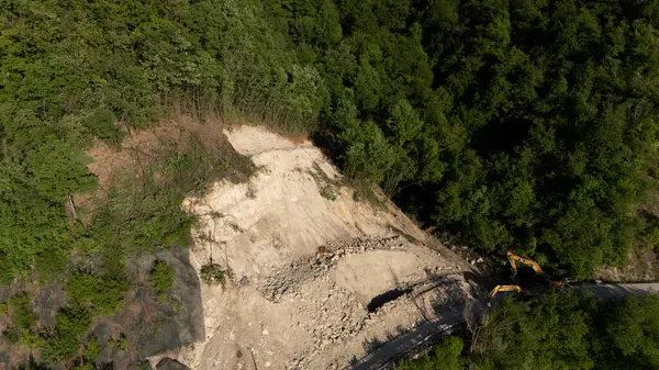 Mignano, İtalya - 22 Nisan 2025 SP21 Vernasca üzerindeki heyelana acil müdahale kazıcıların hızla dağ enkazı kaldırmasıyla, Piacenza, İtalya