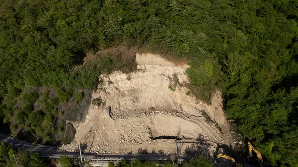 Mignano, İtalya - 22 Nisan 2025 SP21 Vernasca üzerindeki heyelana acil müdahale kazıcıların hızla dağ enkazı kaldırmasıyla, Piacenza, İtalya