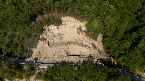 Mignano, İtalya - 22 Nisan 2025 SP21 Vernasca üzerindeki heyelana acil müdahale kazıcıların hızla dağ enkazı kaldırmasıyla, Piacenza, İtalya