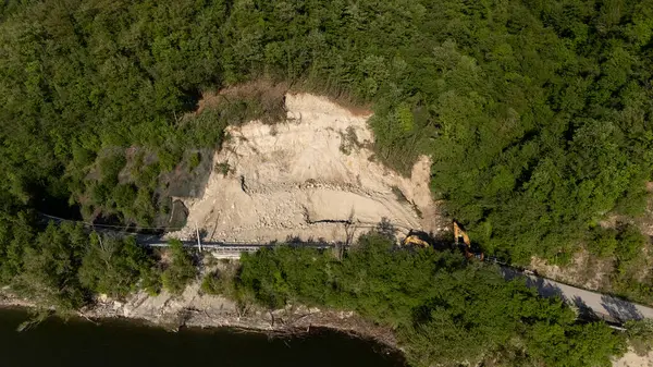 Mignano, İtalya - 22 Nisan 2025 SP21 Vernasca üzerindeki heyelana acil müdahale kazıcıların hızla dağ enkazı kaldırmasıyla, Piacenza, İtalya