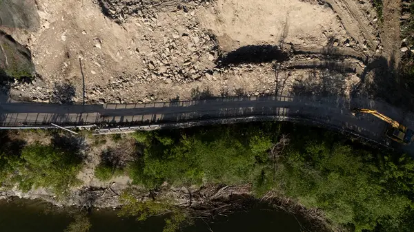 Mignano, İtalya - 22 Nisan 2025 Havadan çekilen ve Mignano Barajı 'nda engellenmiş SP21 Vernasca fotoğrafı, yol kenarında park halindeki kazıcılarla birlikte toprak kayması yaşıyor